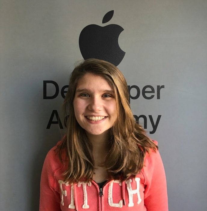 Jessica Hollander na Apple Developer Academy, em frente ao logo da academia.